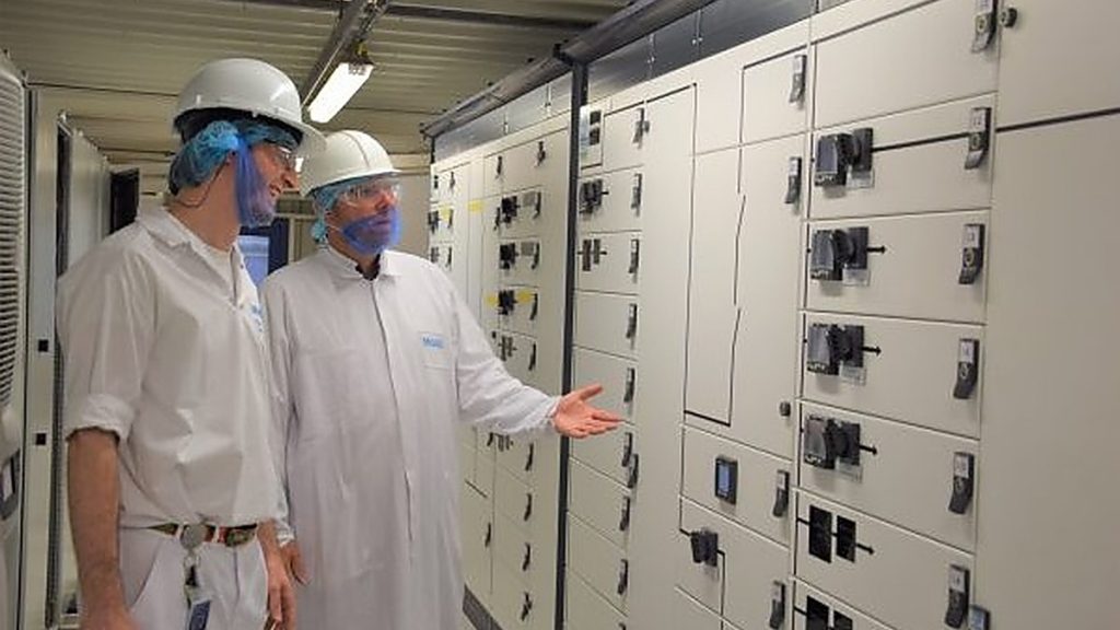 Medewerkers inspecteren de vernieuwde besturingskasten van de proceskeuken in de Mars-fabriek in Oud-Beijerland. Actemium in Nederland.