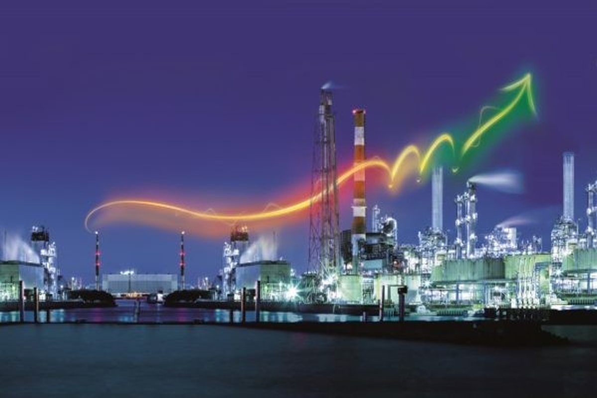Verlicht industrieel productiecomplex met stijgende lichtlijn die groei in energie-efficiëntie en procesoptimalisatie symboliseert. Actemium in Nederland.