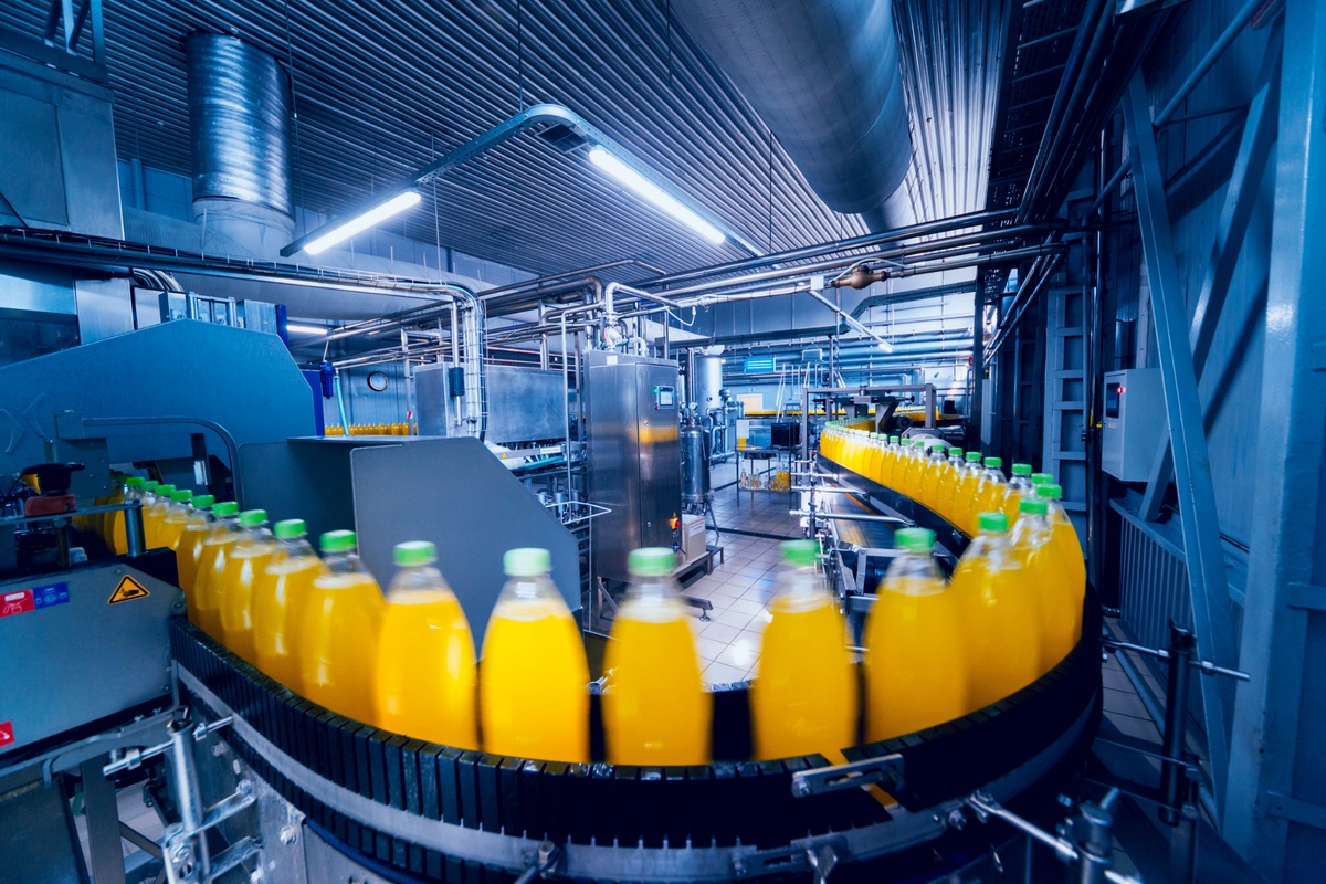 Geautomatiseerde productielijn met flessen in een voedingsmiddelenfabriek, gericht op een betrouwbare en continue productie. Actemium in Nederland.