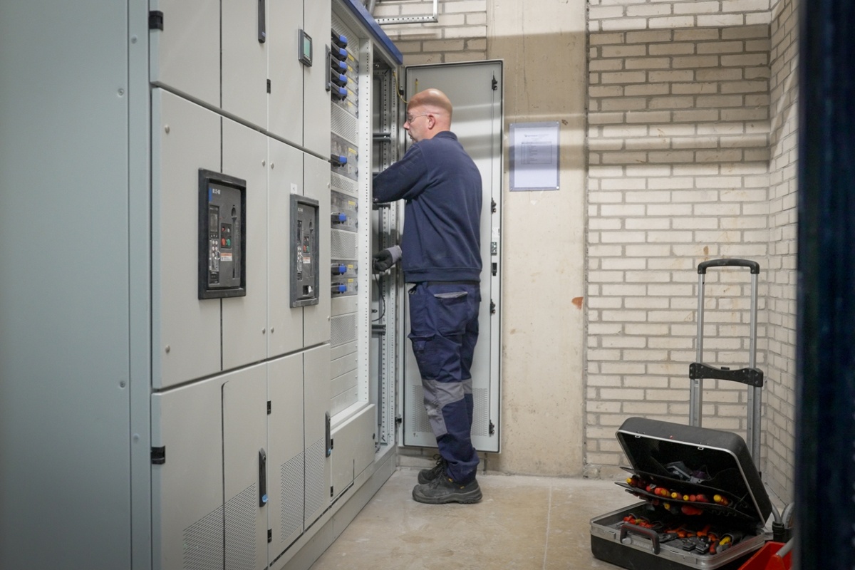Elektromonteur gebouwgebonden installaties aan het werk bij Senefelder Misset vanuit Actemium In Doetinchem aan een elektrotechnische kast.