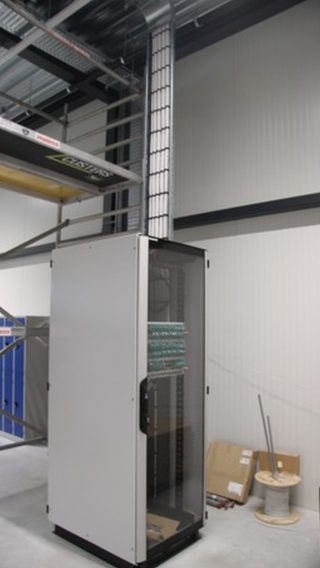 Actemium realiseert communicatie-installaties voor betrouwbare data- en netwerkverbindingen. Op de afbeelding is een netwerk- of patchkast te zien met bekabeling, connectoren en actieve netwerkcomponenten in een technische ruimte.