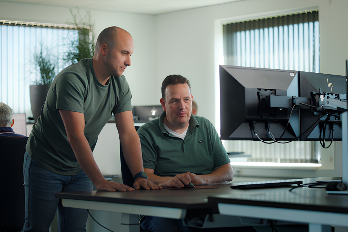 Actemium hardware engineering specialist werkt aan een ontwerp voor industriële automatisering. Op de foto bekijken twee engineers een technische configuratie op meerdere beeldschermen, waarbij besturingssystemen en elektrotechnische installaties voor industriële processen worden ontworpen en voorbereid.