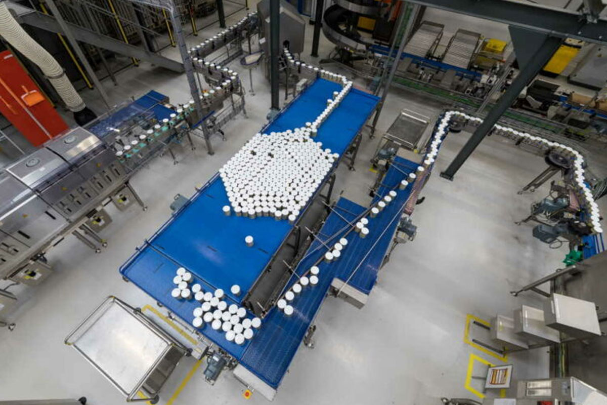 Geautomatiseerde productielijn bij Danone Nutricia in Haps, waar verpakkingen via transportsystemen worden verwerkt en getransporteerd binnen een moderne voedingsmiddelenfabriek mium in Nederland