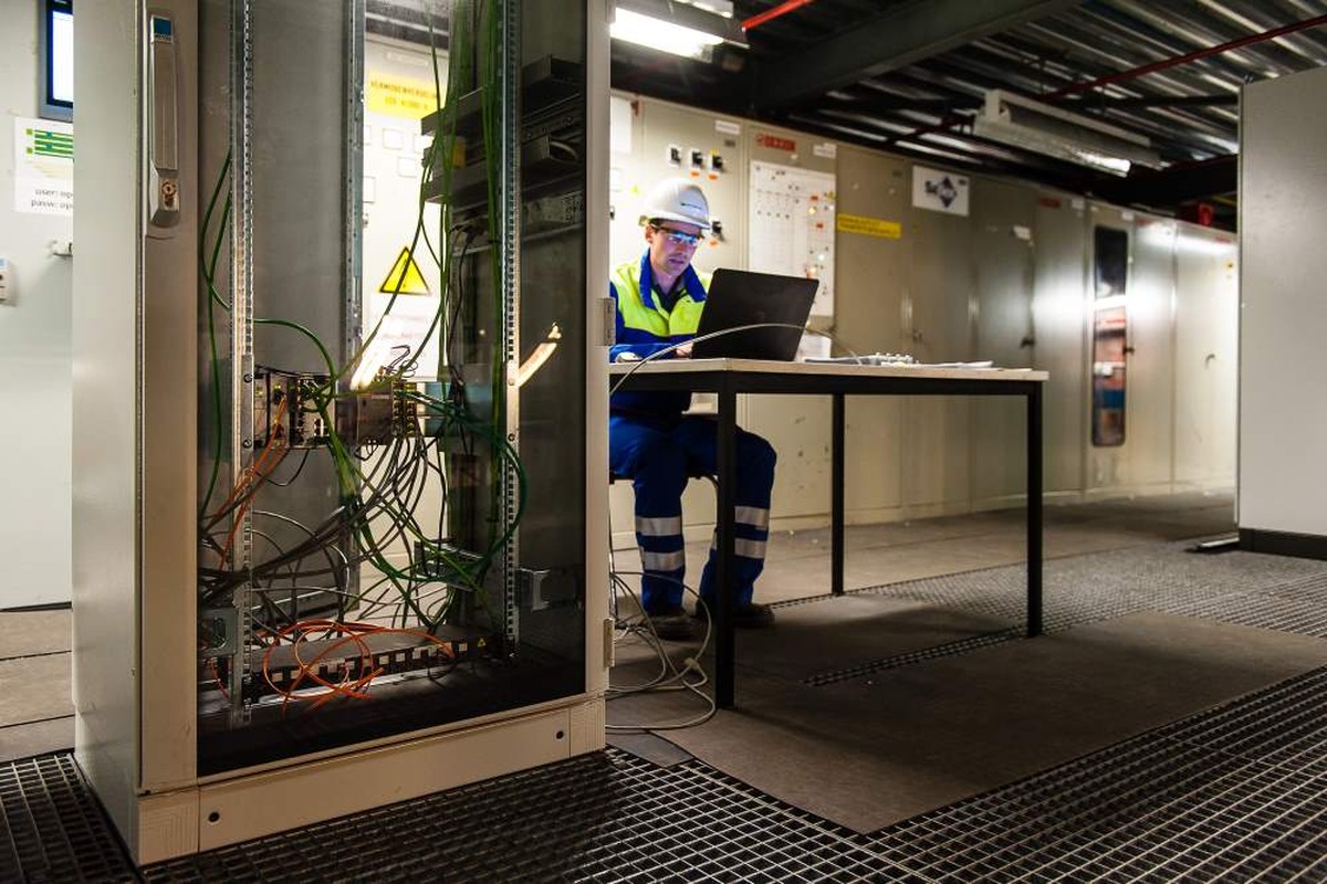 Actemium verlengt de levensduur van industriële installaties met retrofit-oplossingen. Op de afbeelding staan twee medewerkers bij een geopende besturingskast met PLC- en automatiseringscomponenten, terwijl instellingen en documentatie worden gecontroleerd.