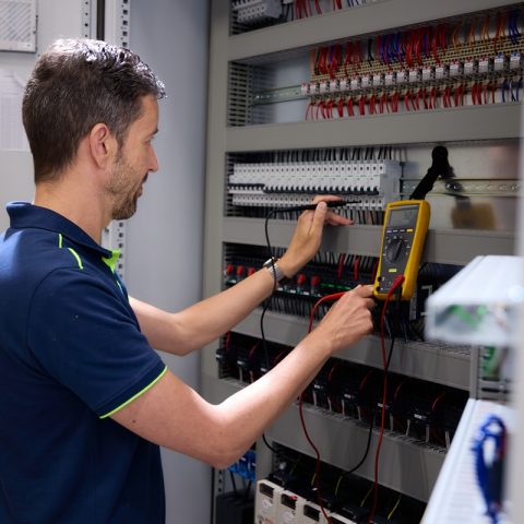 Medewerker test paneelkast met meter op spanning Actemium in Nederland locatie Schijndel