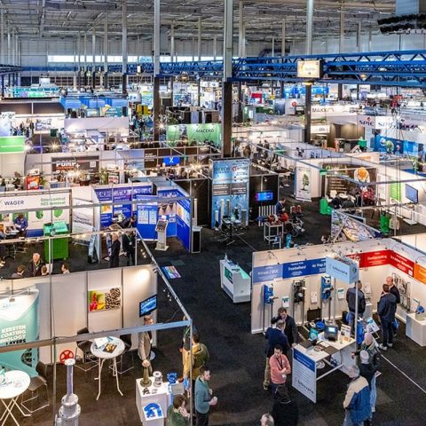 Overzicht van Aqua Nederland vakbeurs met stands en bezoekers in de watersector
